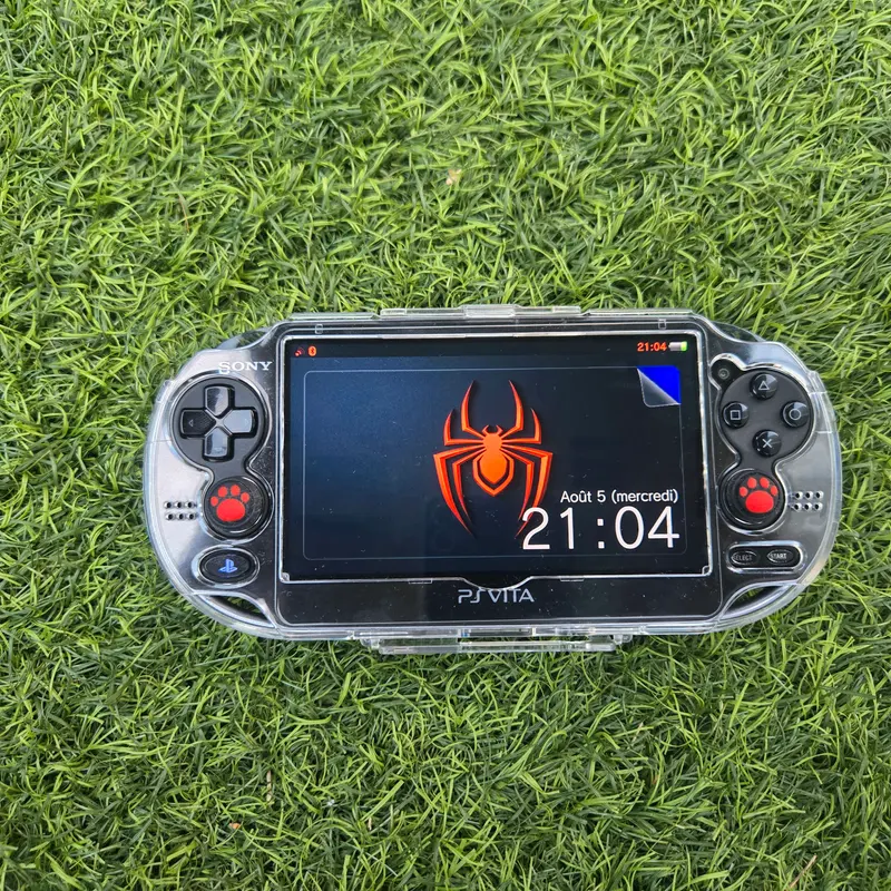 PS Vita 1000 noire en coque transparente, écran OLED allumé sur un thème Flower Boy