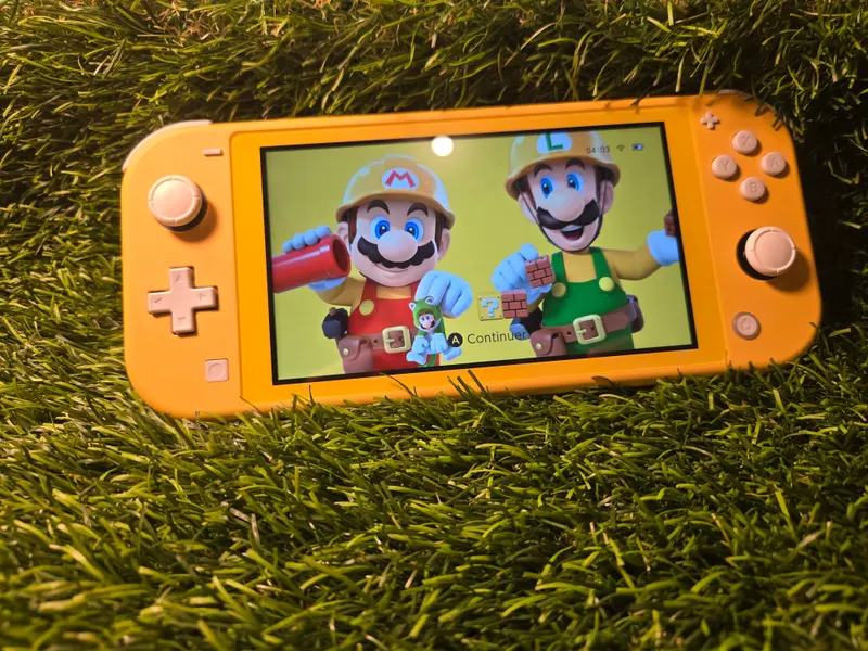 Nintendo Switch Lite jaune, écran allumé sur un thème Super Mario