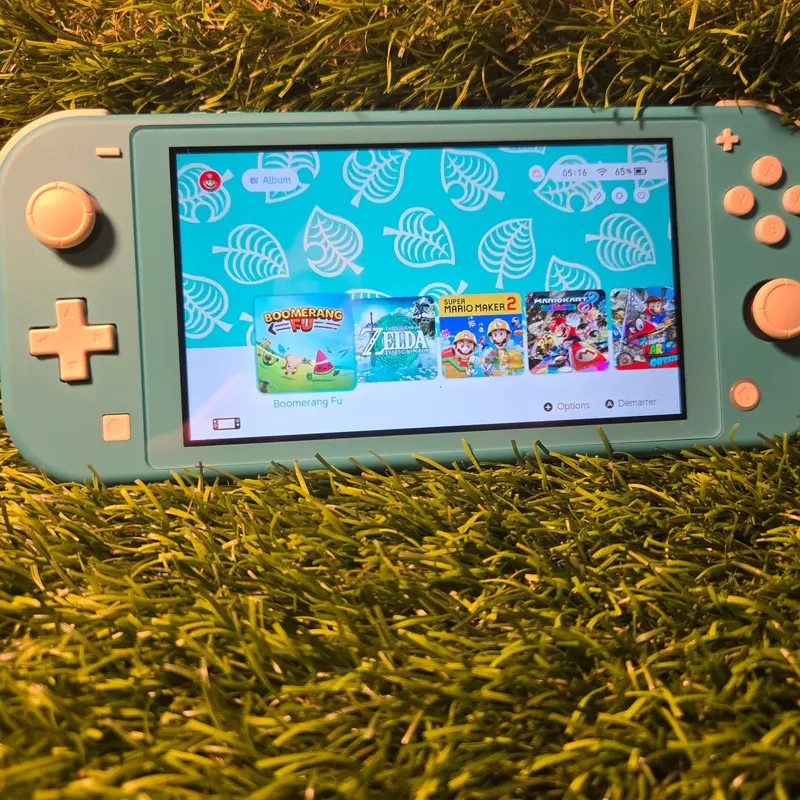 Nintendo Switch Lite turquoise posée devant sa boîte Animal Crossing